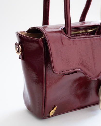 Detalles del bolso satchel Lu de Luna Lenore en el que se puede ver una de las argollas para usarla como crossbody, la esquina de la tapa en la que pueden verse sus costuras y el tachon de logotipo de Luna Lenore